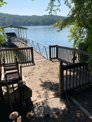 A boat is docked at a dock next to a lake.