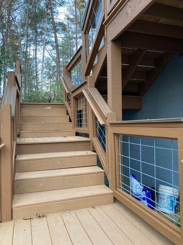 A wooden deck with stairs leading up to the second floor.