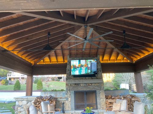 A gazebo with a fireplace and a television on the wall.
