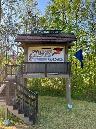 A wooden structure with stairs and a sign on top of it.