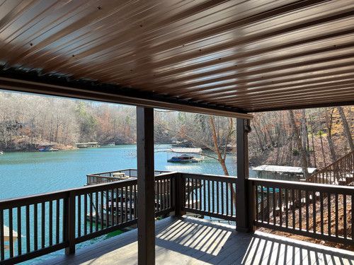 A deck with a view of a lake and trees.