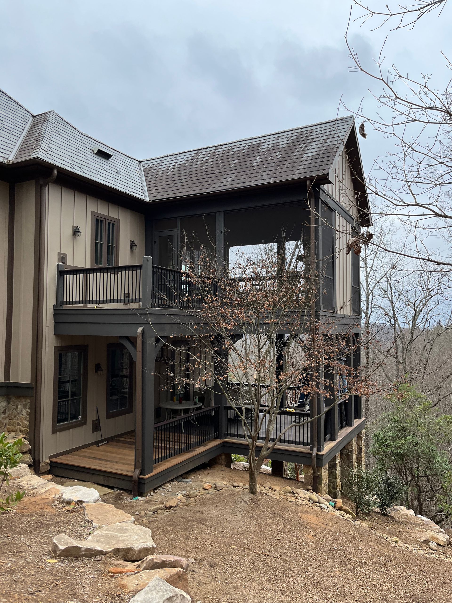 A large house with a screened in porch on the side of it.