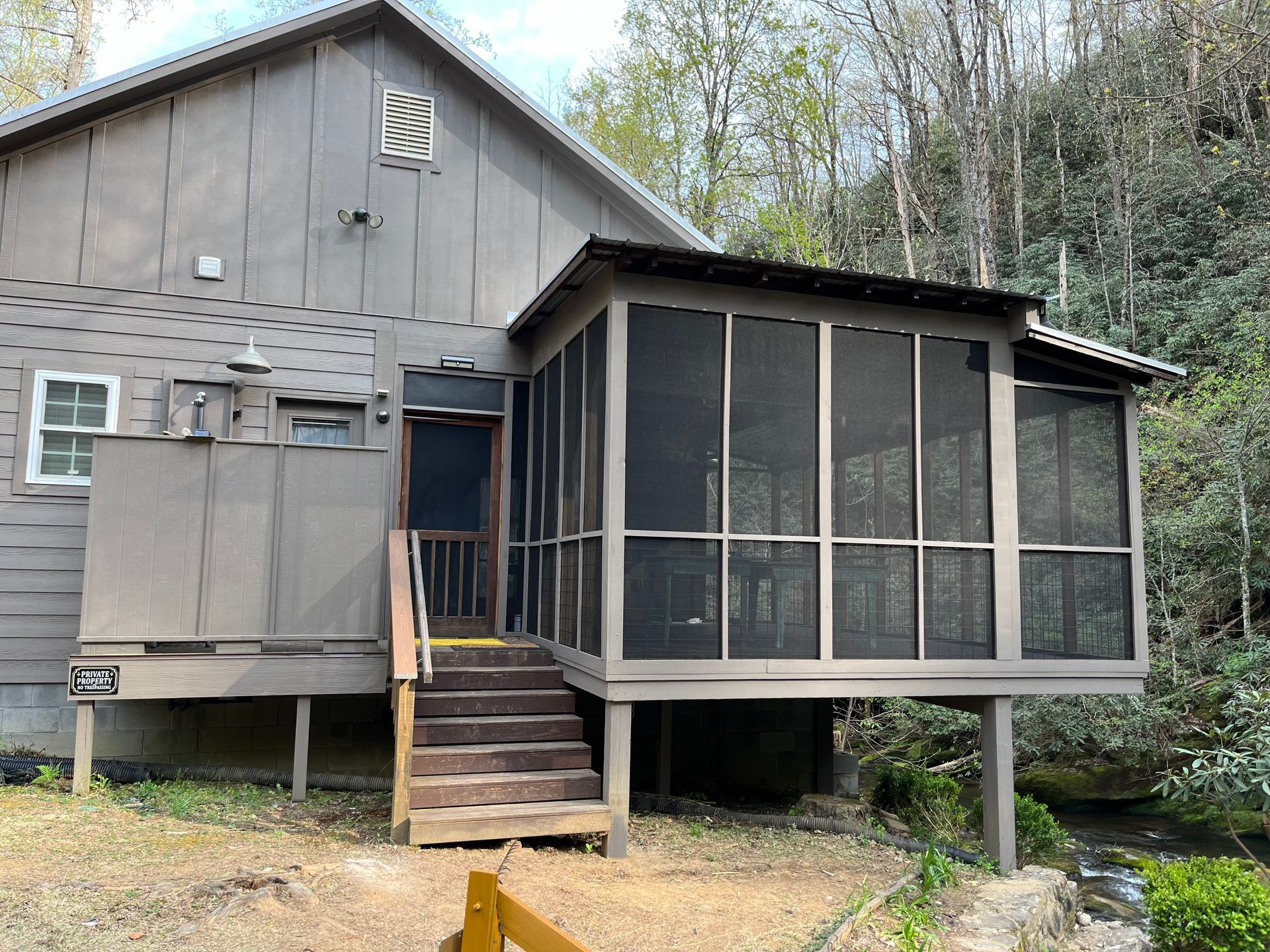 A house with a screened in porch and stairs