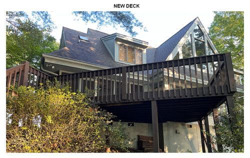 A picture of a house with a deck on top of it.