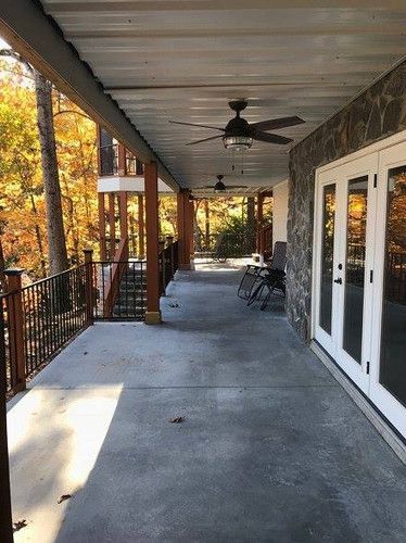 There is a ceiling fan on the porch of a house.