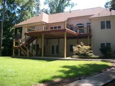 A large house with a large deck on the back of it
