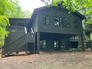 A long gray deck with a stone wall in the background.
