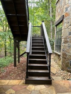 A set of wooden stairs leading up to a wooden deck.