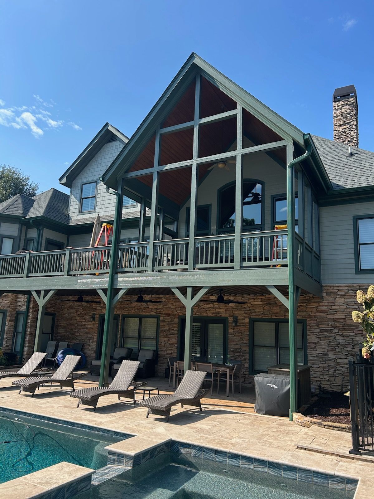A long gray deck with a stone wall in the background.