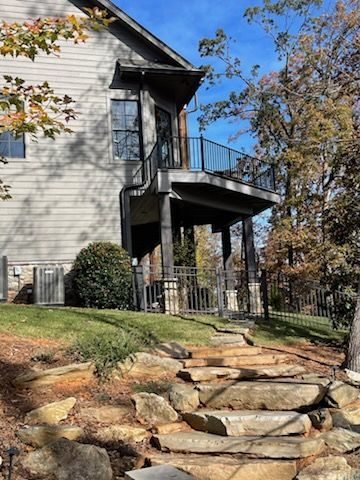 A house with a deck and stairs leading up to it.