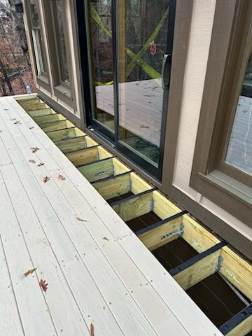 A wooden deck under construction with a sliding glass door.