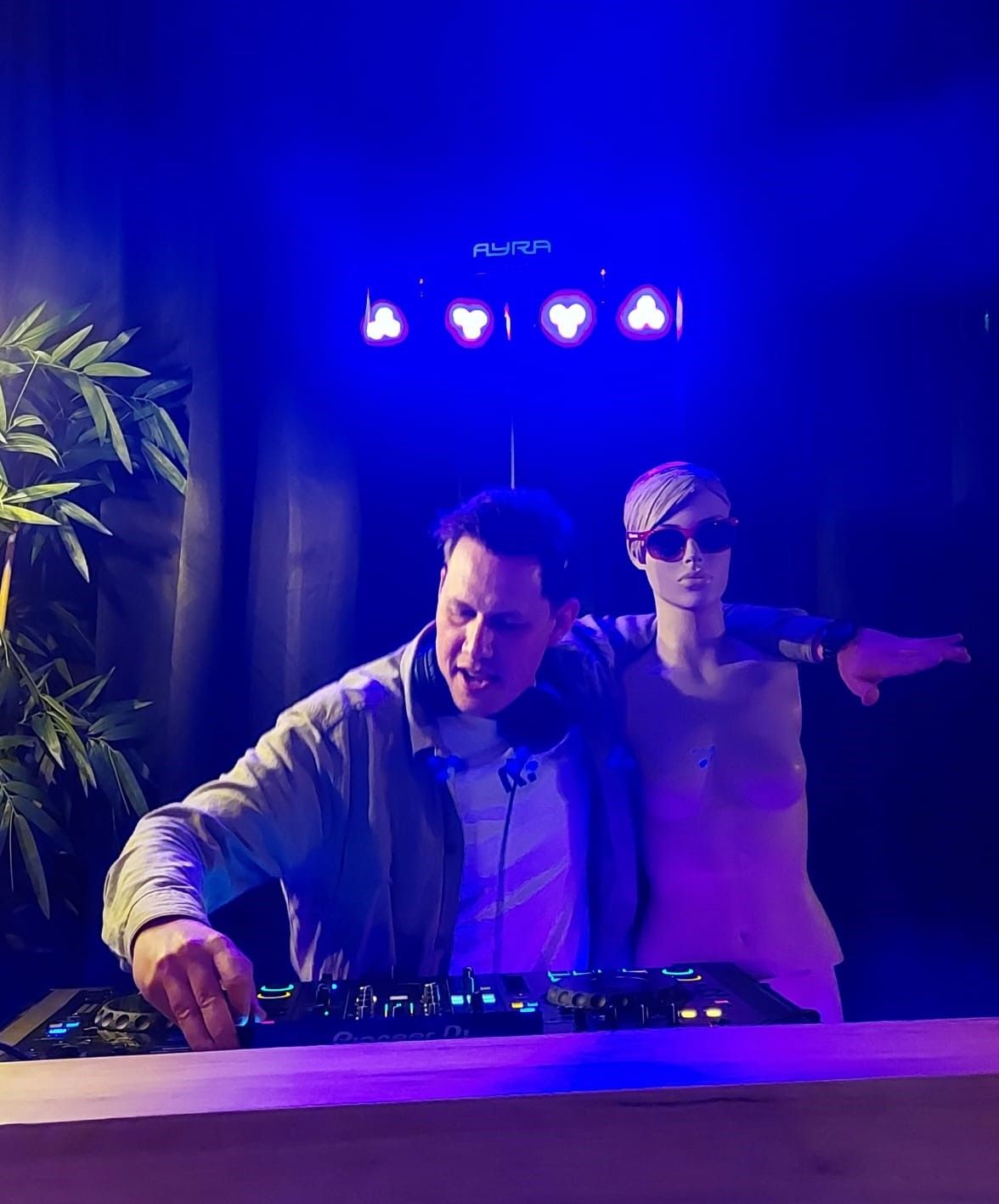 DJ Skip naast paspop onder blauw licht