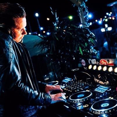 Een man in een leren jas speelt een dj-set