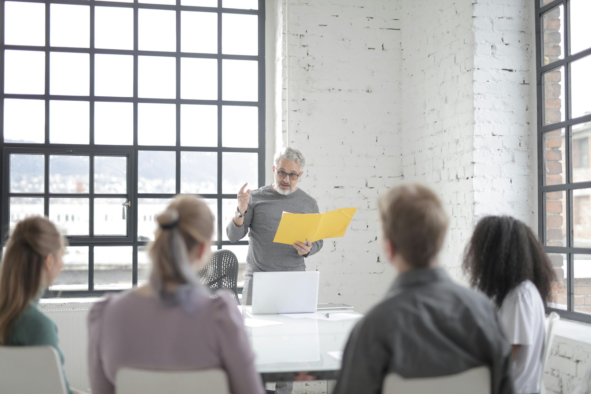 A man is giving a presentation to a group of people sitting at a table.