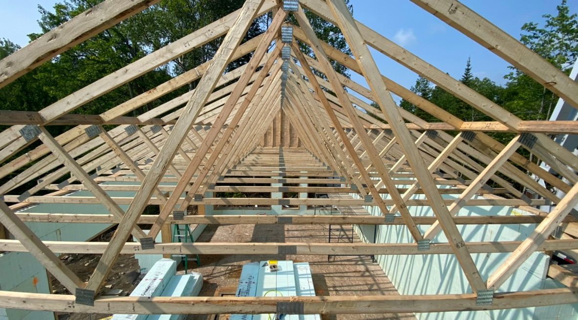 Construction de charpentes de toit en bois sur un bâtiment ; vue de l'intérieur.