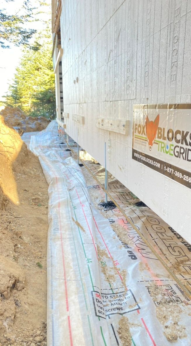 Fondations d'un bâtiment avec bâche de protection au sol.