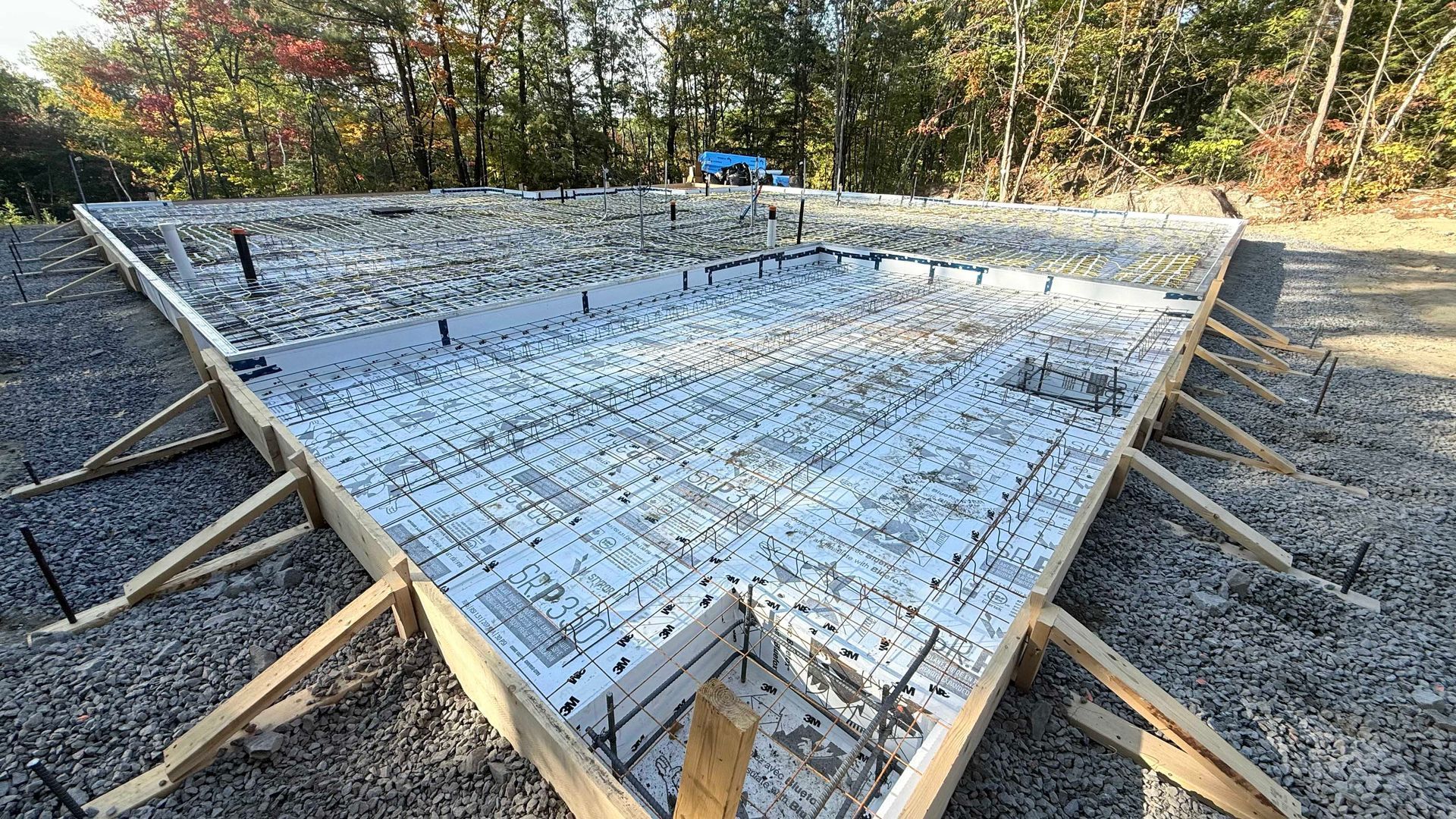 Fondation triangulaire en béton armé, à l'intérieur d'une ossature en bois, à l'extérieur.
