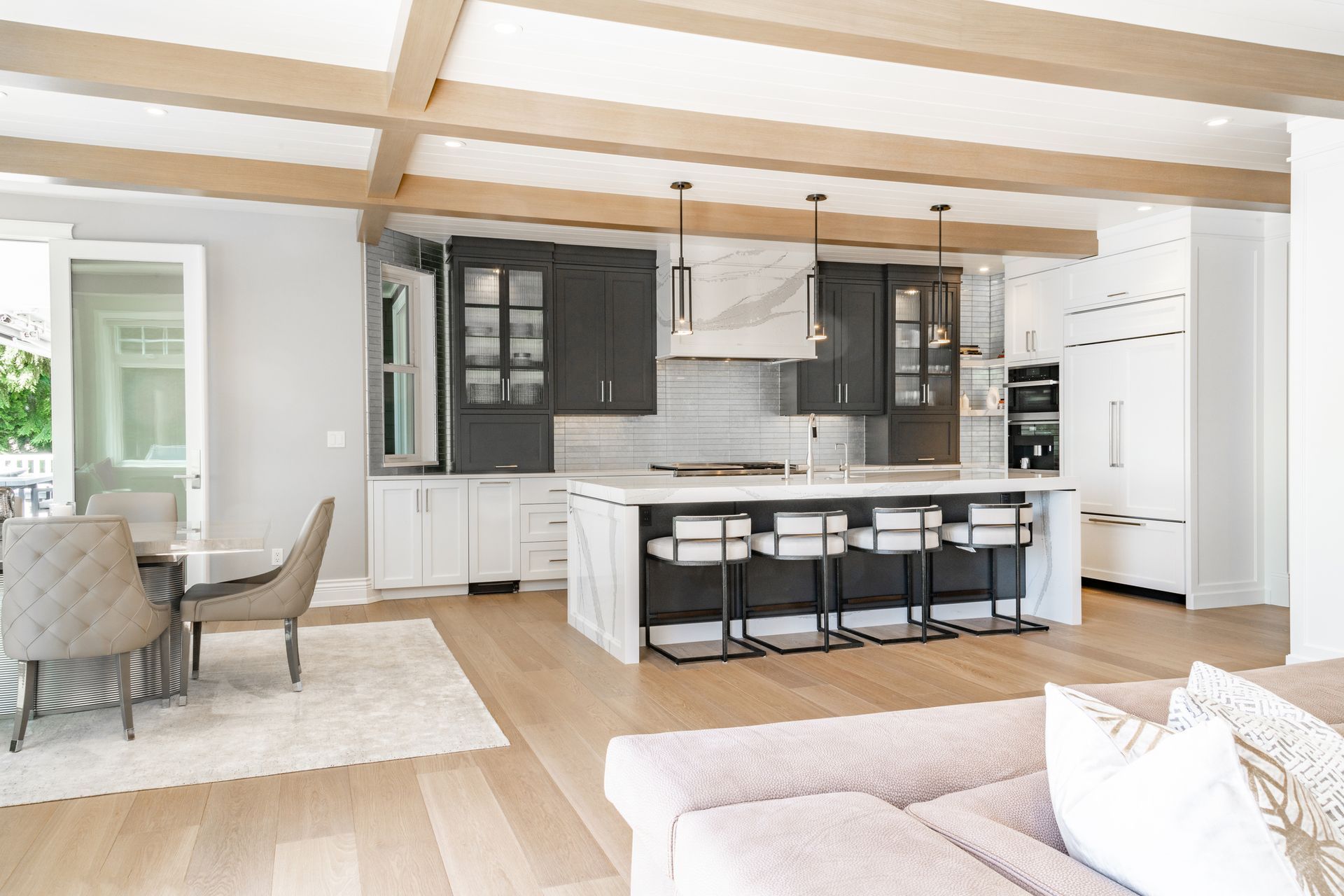 A living room with a couch , chairs , and a kitchen with a large island.