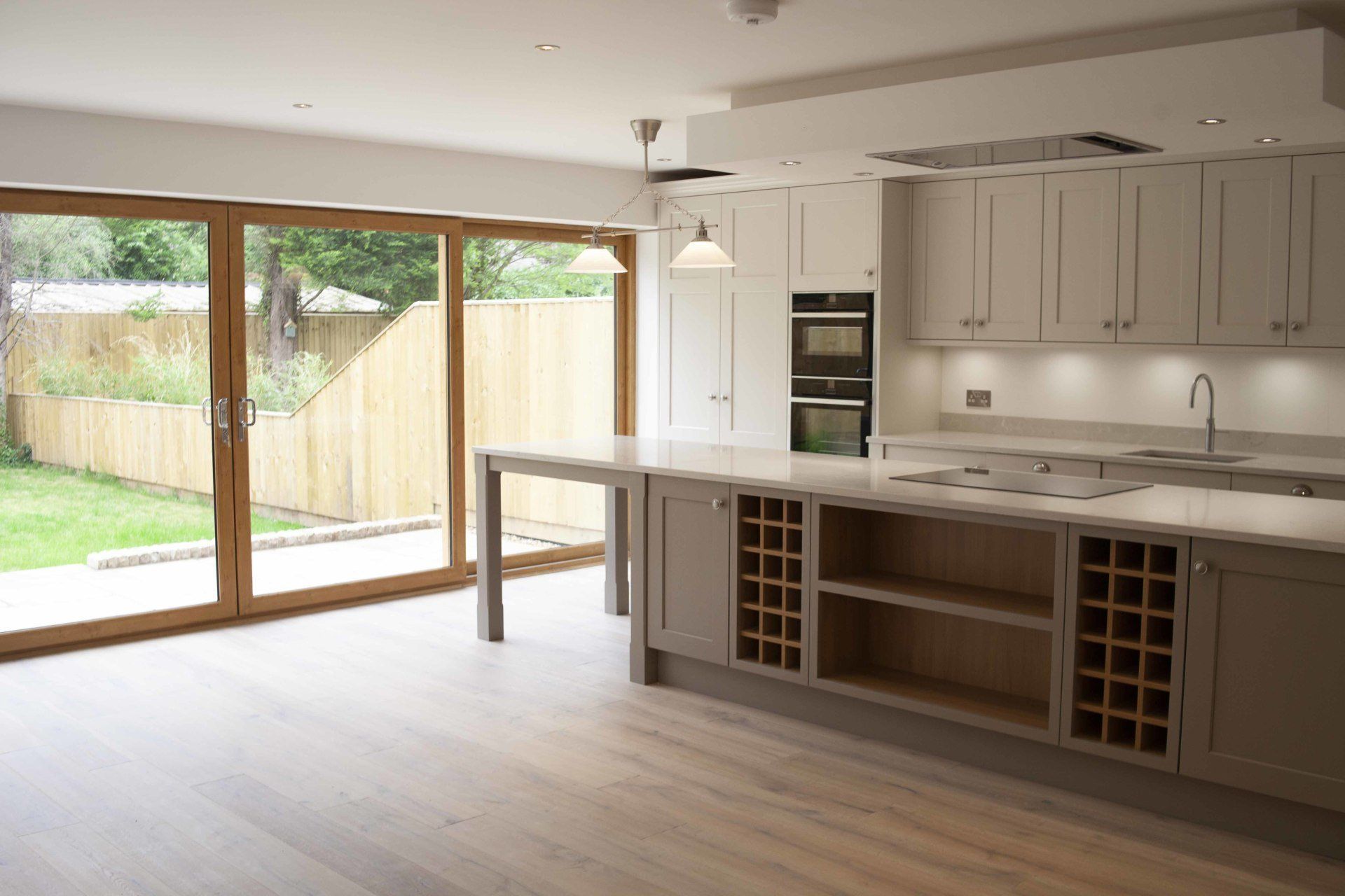 An empty kitchen with sliding glass doors leading to a backyard.