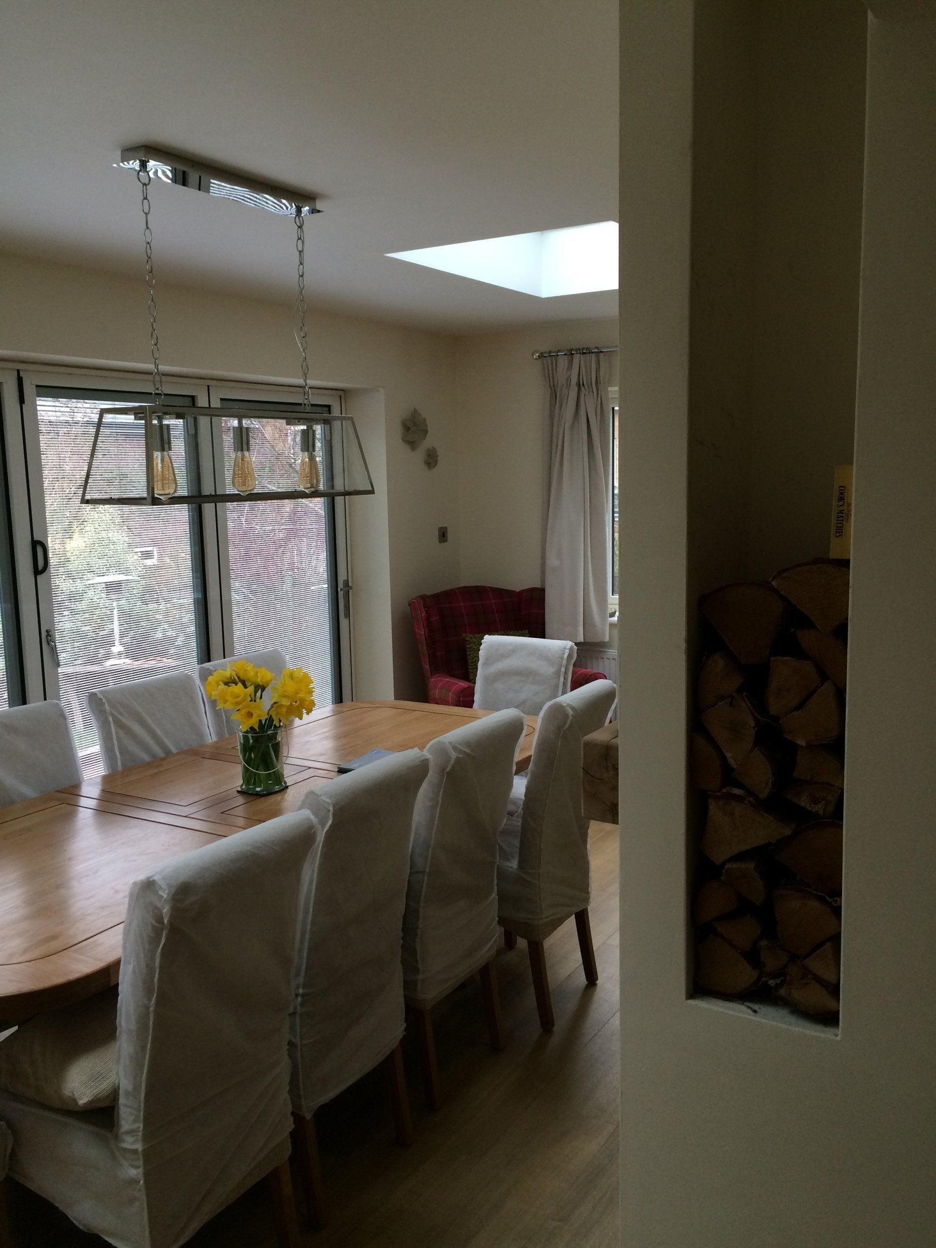A dining room table with a vase of yellow flowers on it