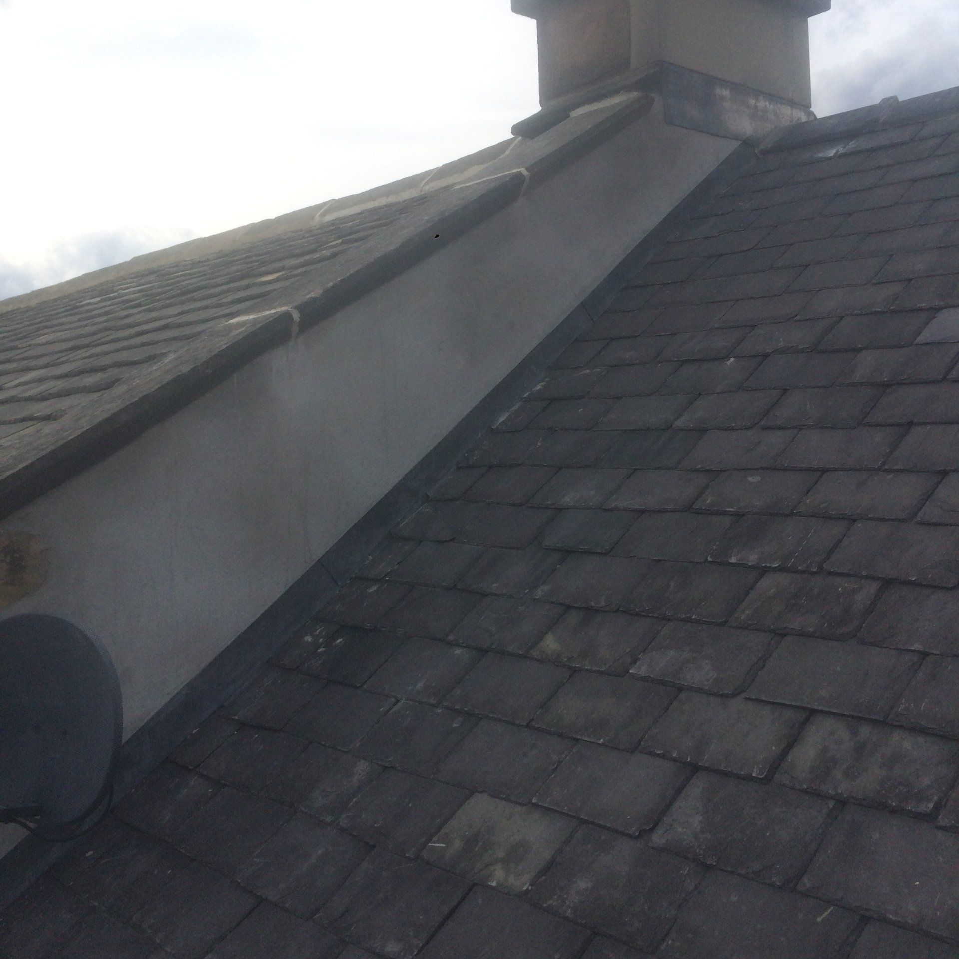 A roof with a chimney on the side of it.