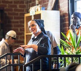 Nun smiling in dayroom with homeless men