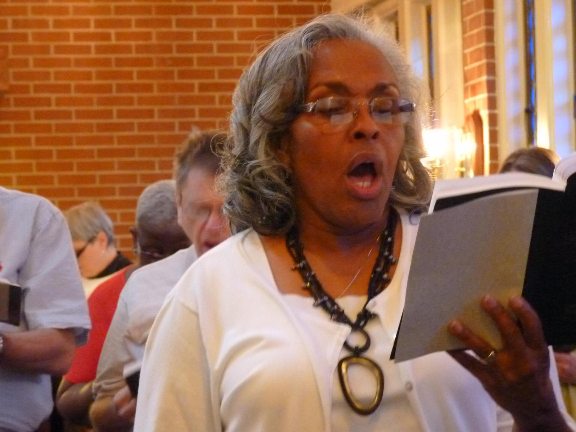 A female member of the congregation singing during worship