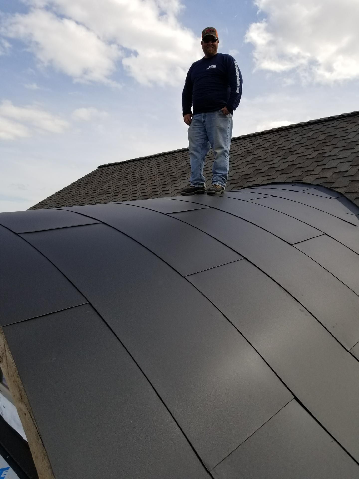 Chad Moore standing on custom metal roof