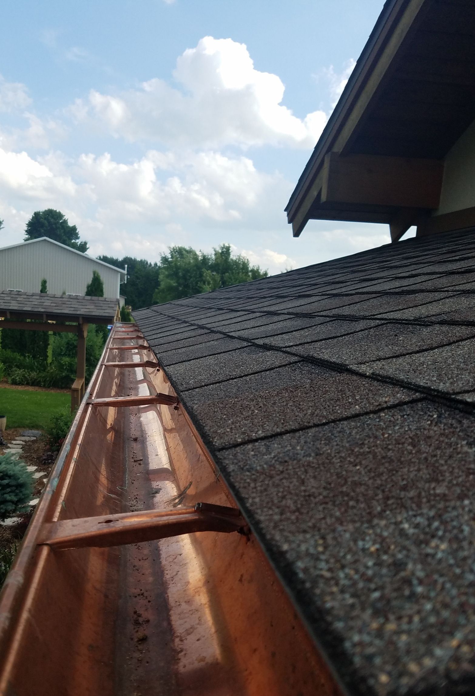 A close up of a gutter on the side of a house.