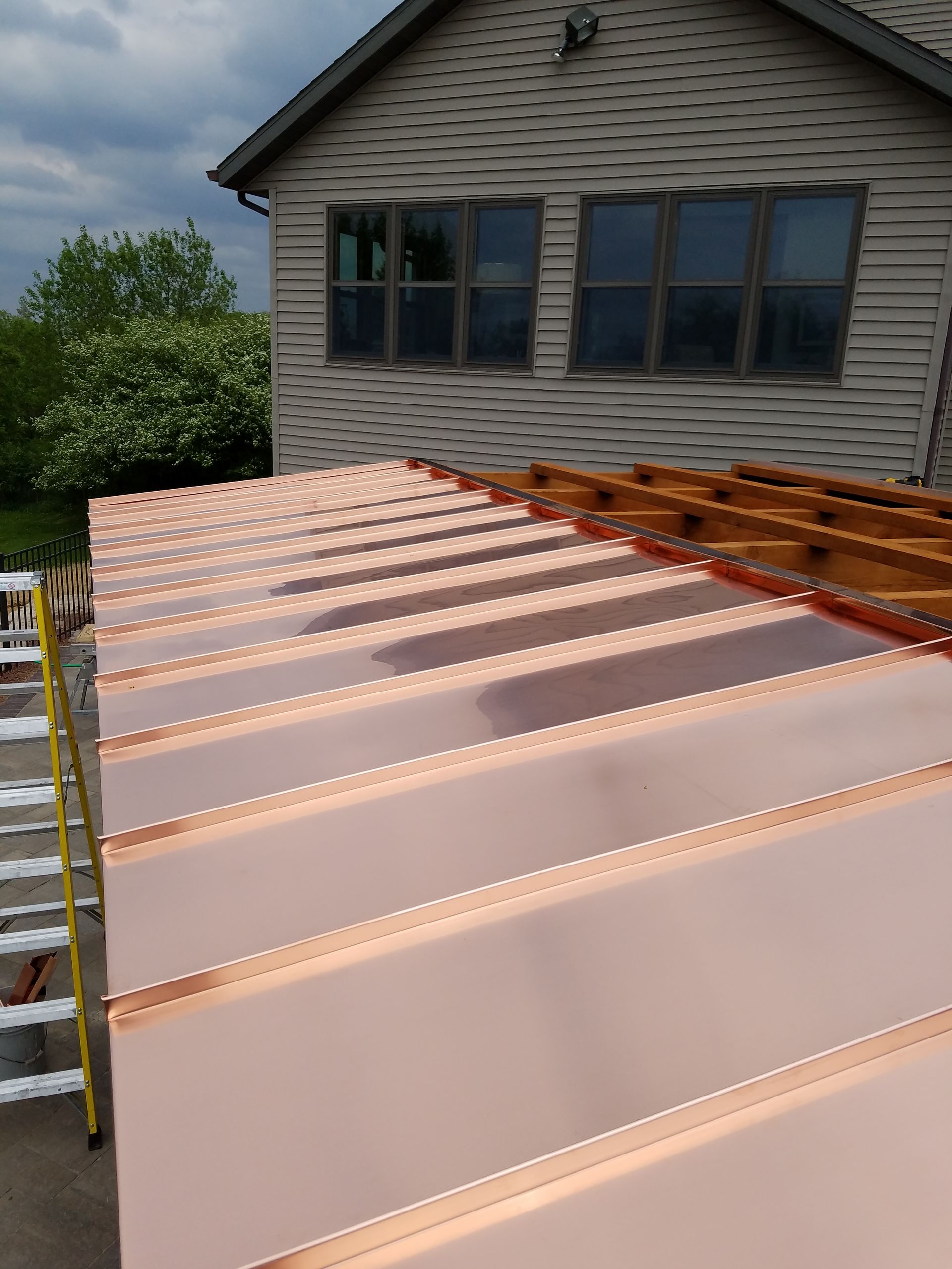 A copper roof is being installed on a house