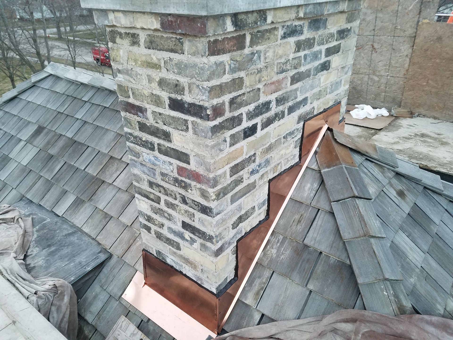 A brick chimney is sitting on top of a roof.