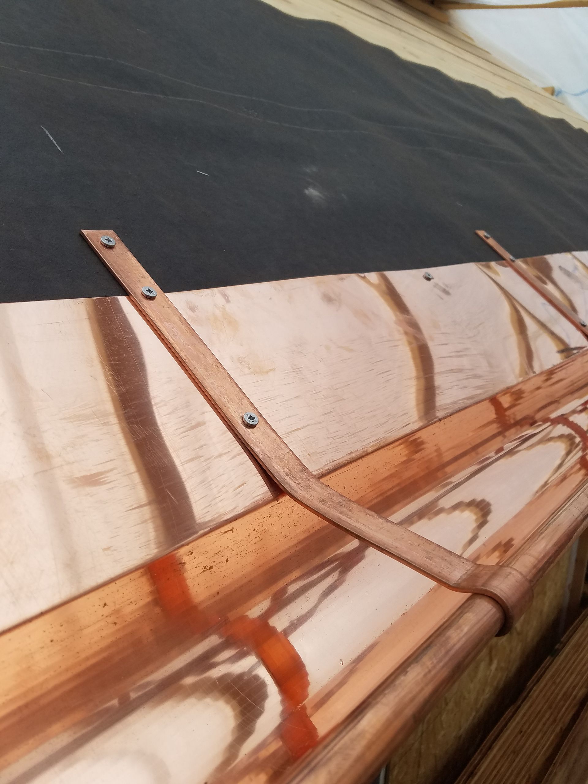 A close up of a gutter on the side of a house.