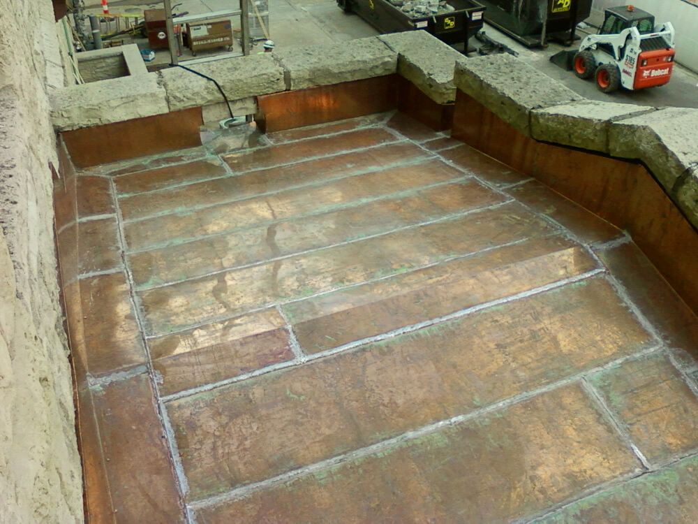 A bobcat is parked on the side of a building