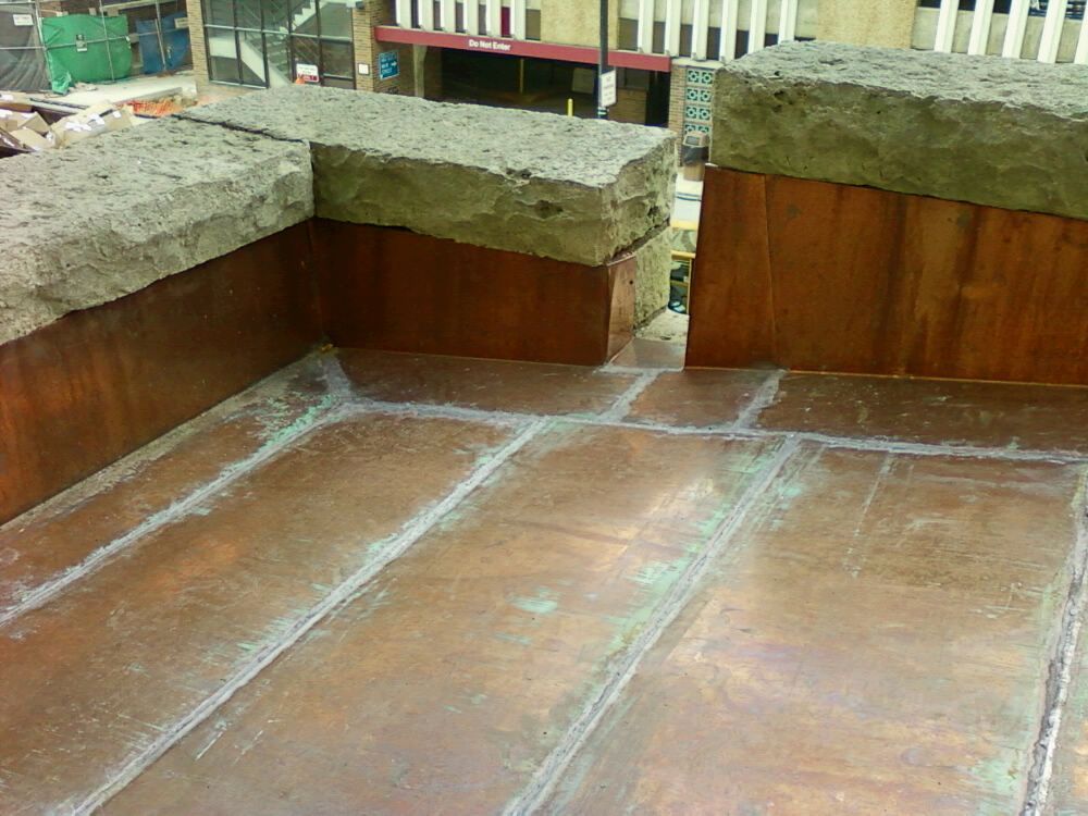 A balcony with a copper roof and a stone ledge