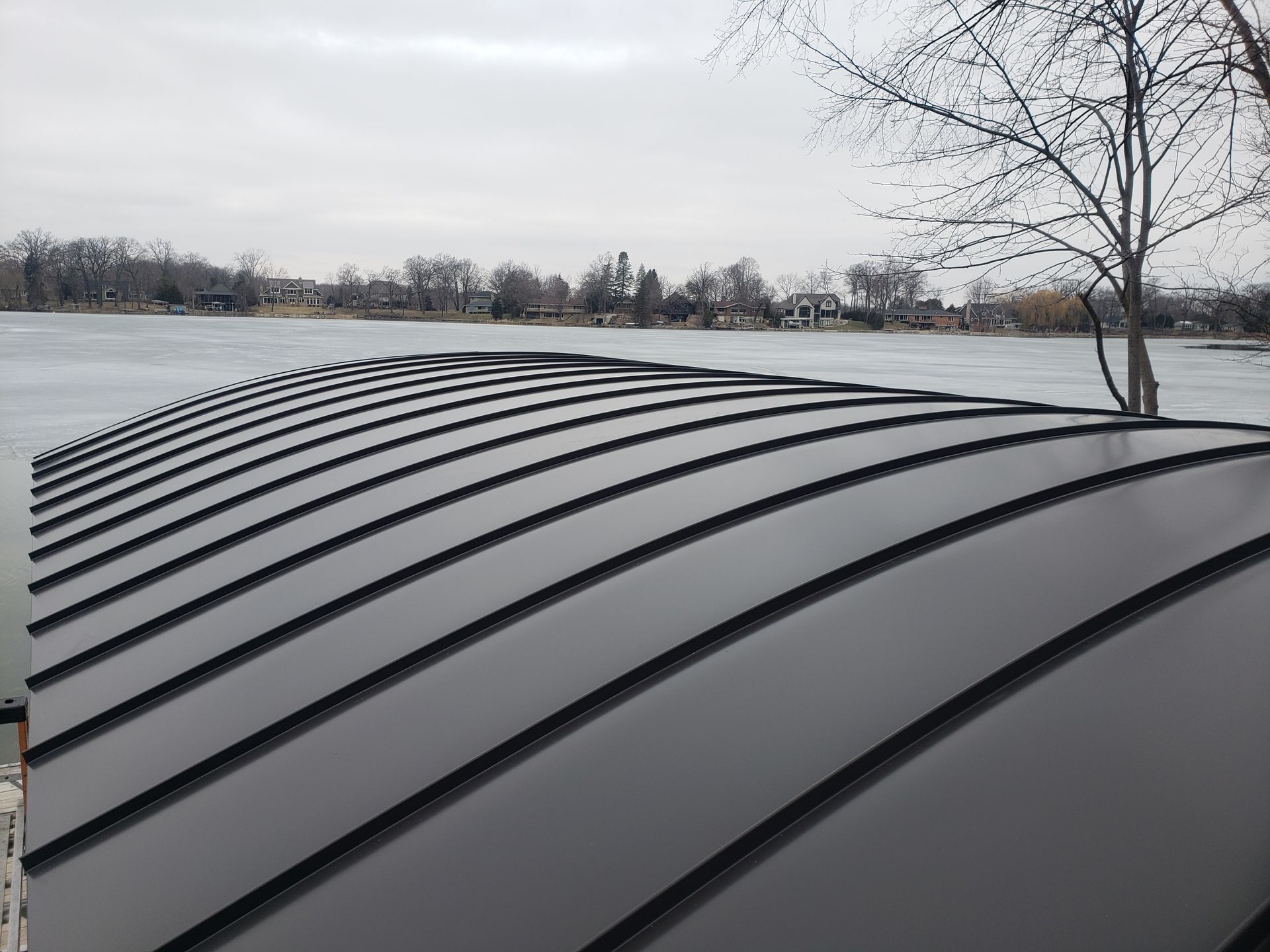 A curved roof with a lake in the background