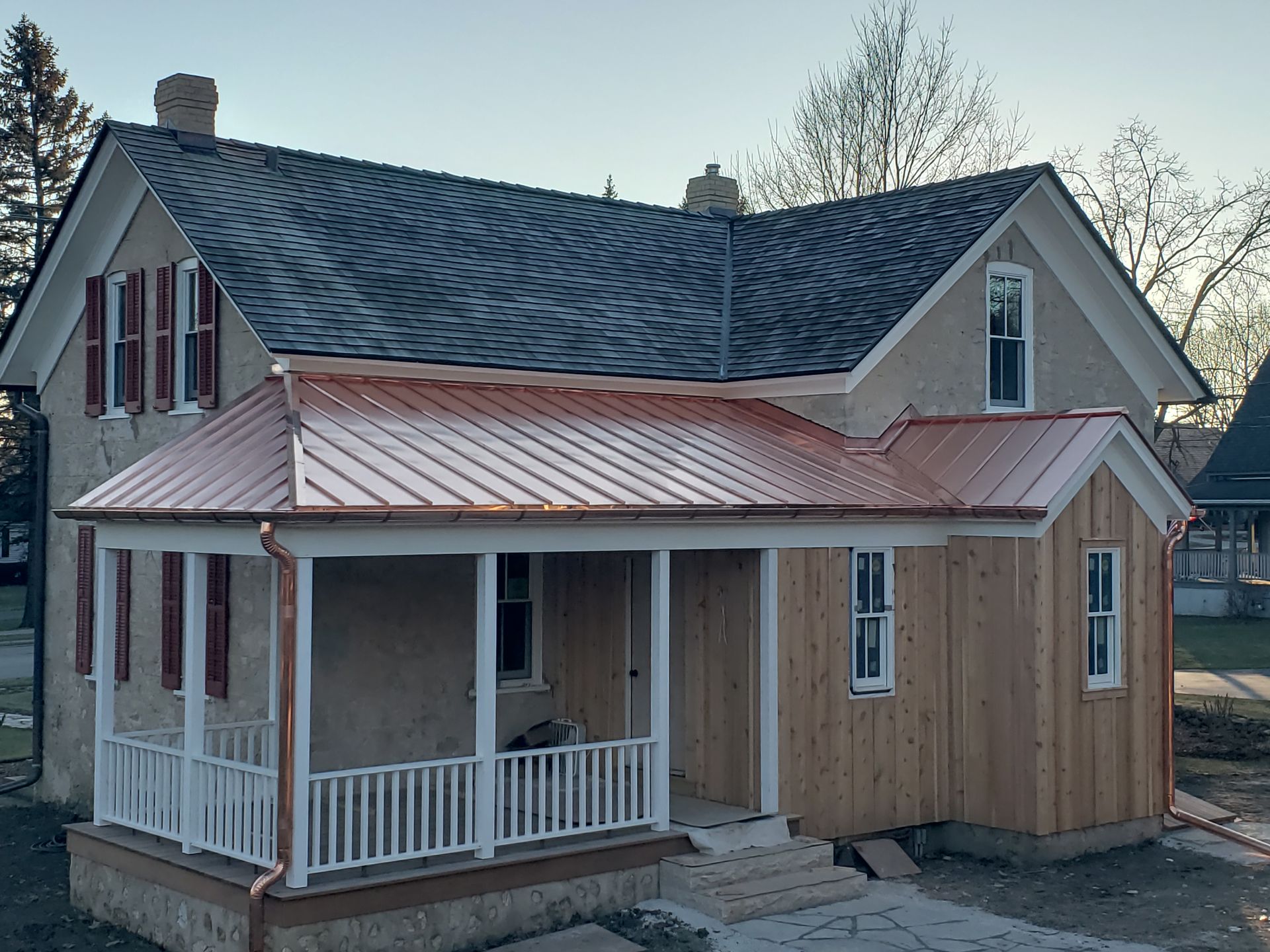 A house with a porch and a copper roof