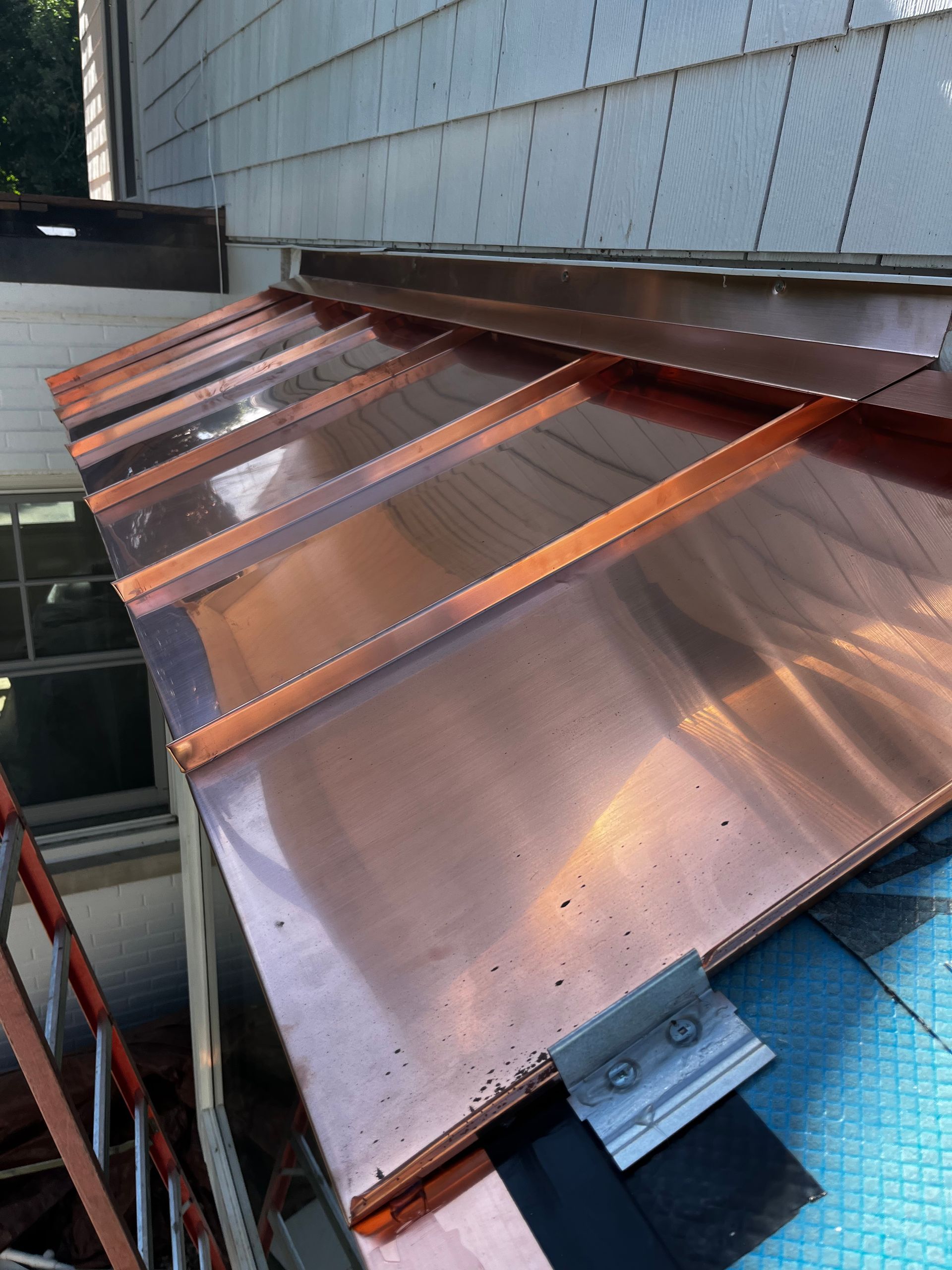 A copper roof is being installed on a house