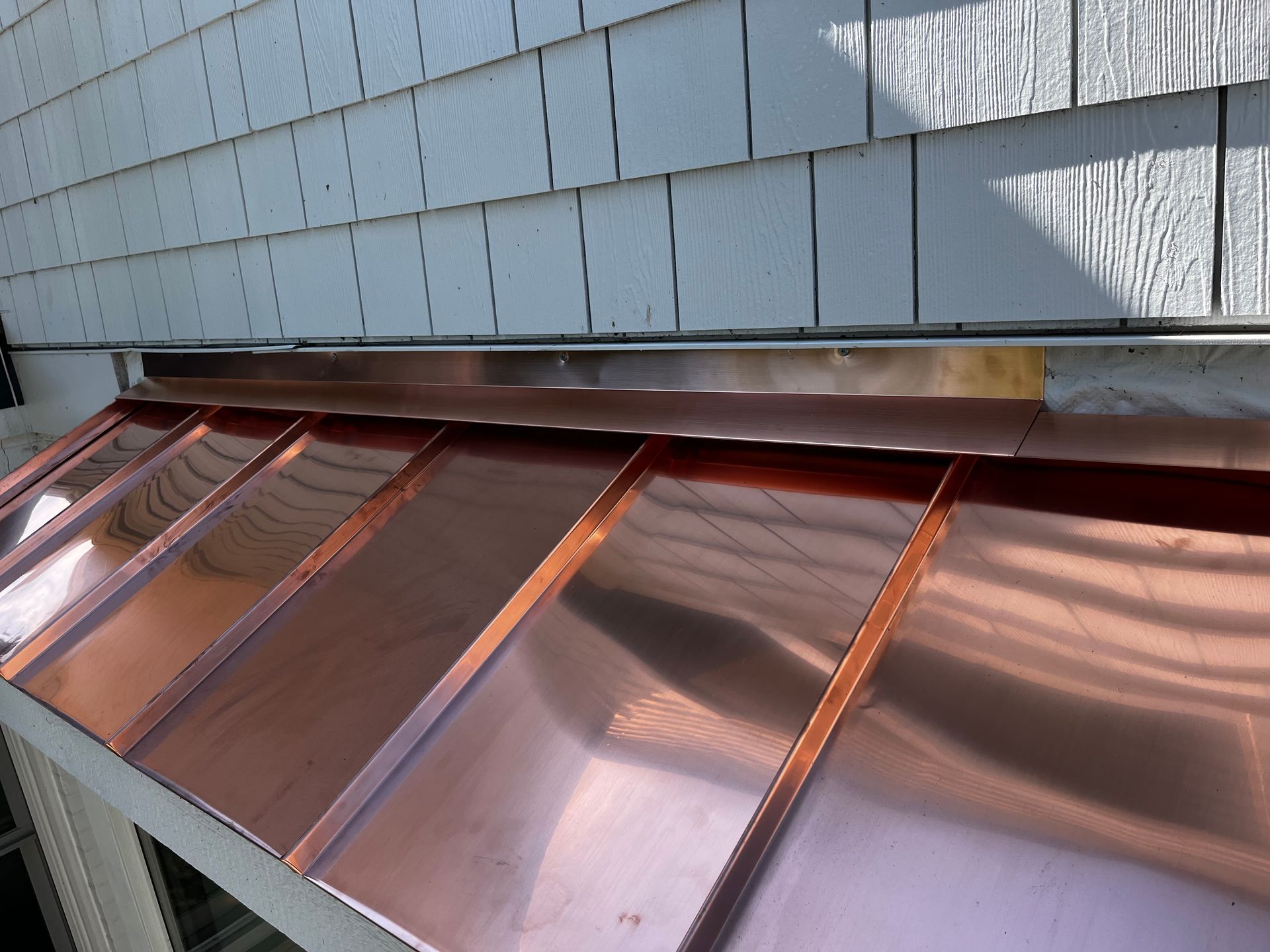 A close up of a copper roof on a house