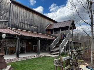 A large wooden barn with stairs leading up to it.
