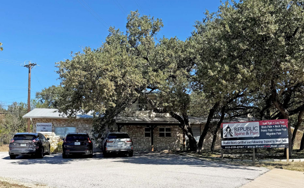 An aerial view of a city with a red arrow pointing to the site