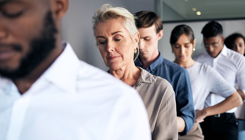 A group of people are standing in a line holding hands.