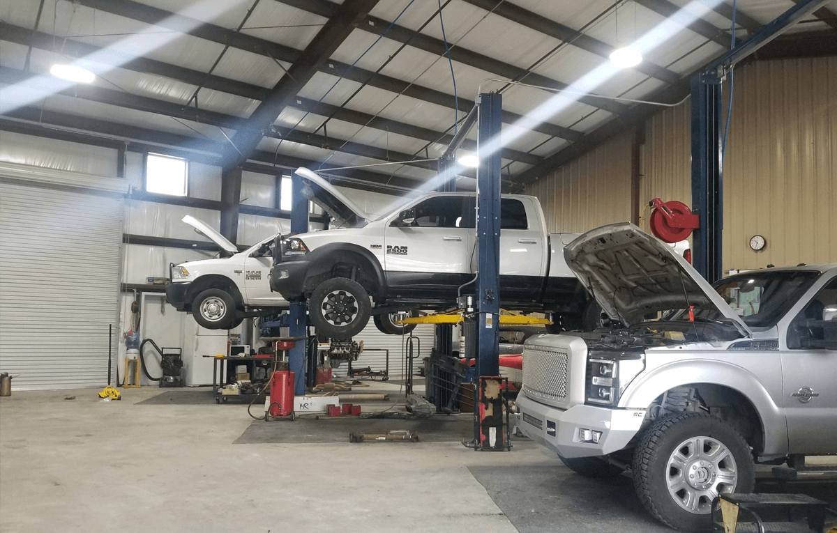 White Car Lifted in Garage | Shift'N Gears Auto Repair