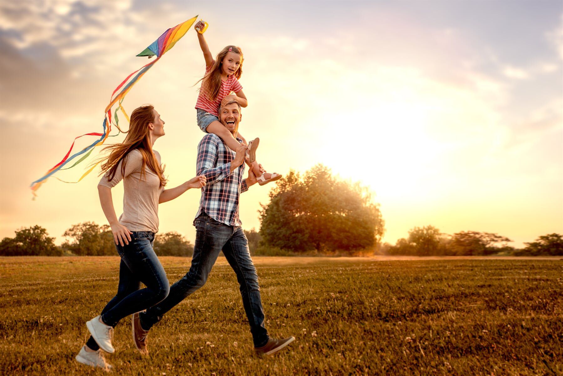 A family is flying a kite in a field.
