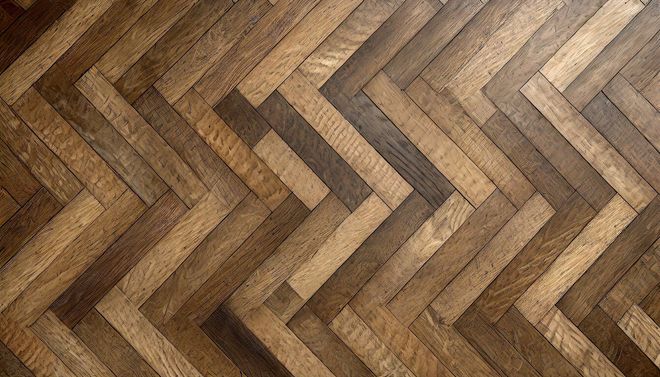 A close up of a wooden floor with a herringbone pattern.