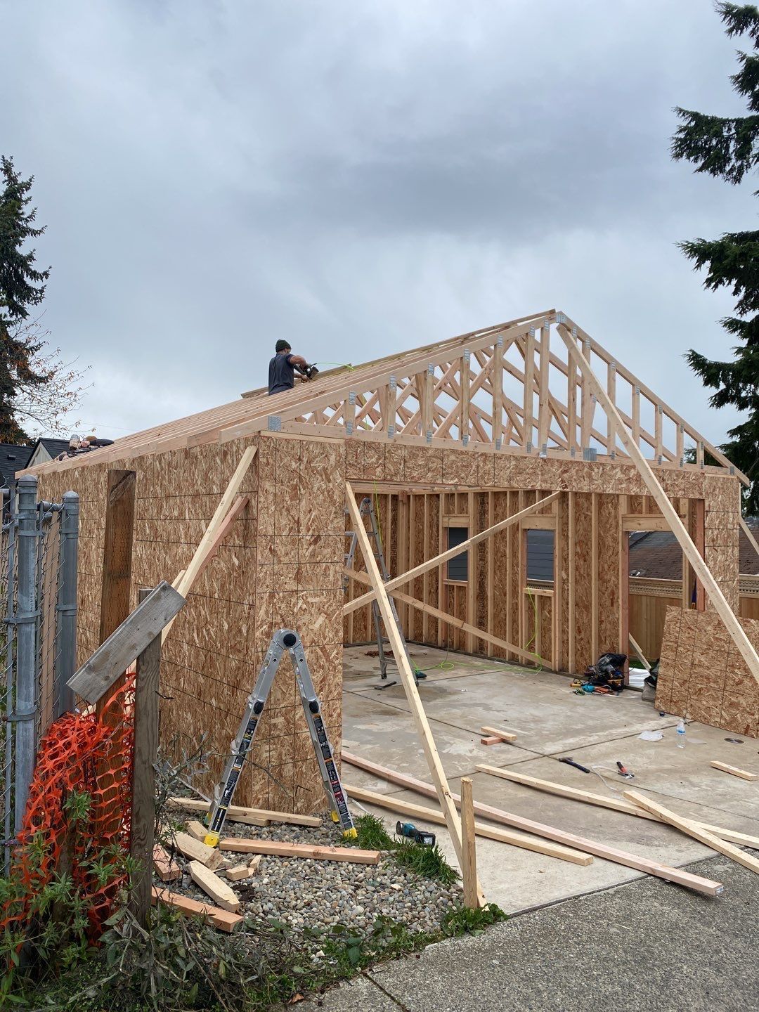 A man is working on the roof of a house under construction.