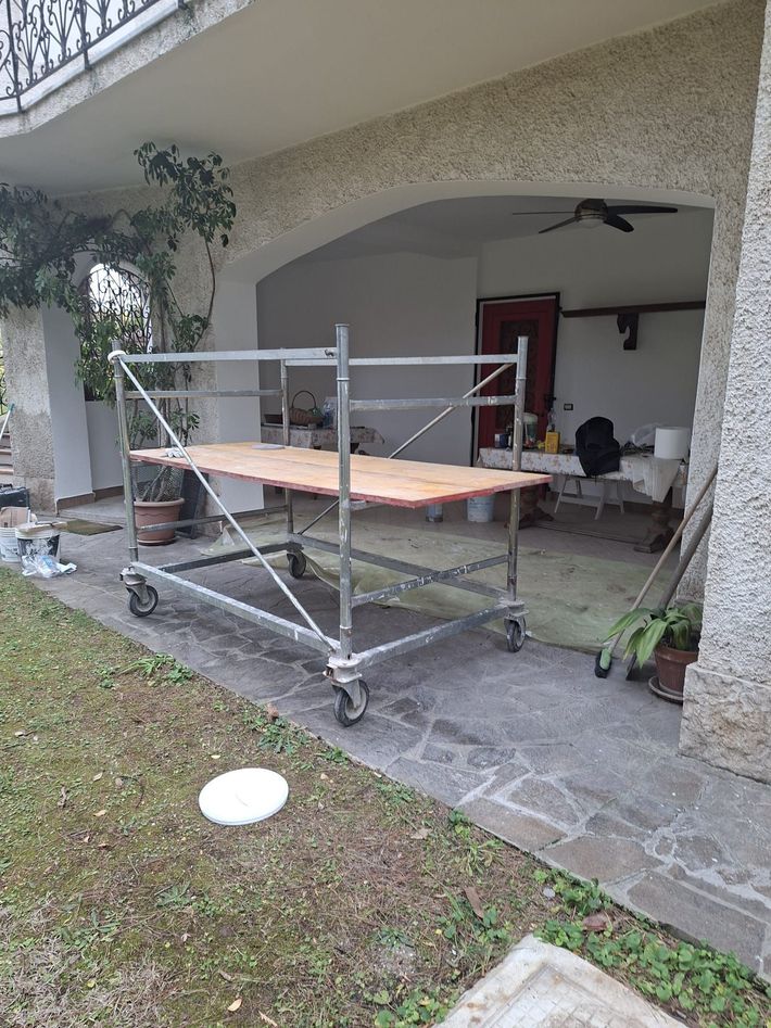 Una persona lavora su un pavimento in legno massello accanto a una grande finestra con gli edifici della città sullo sfondo.