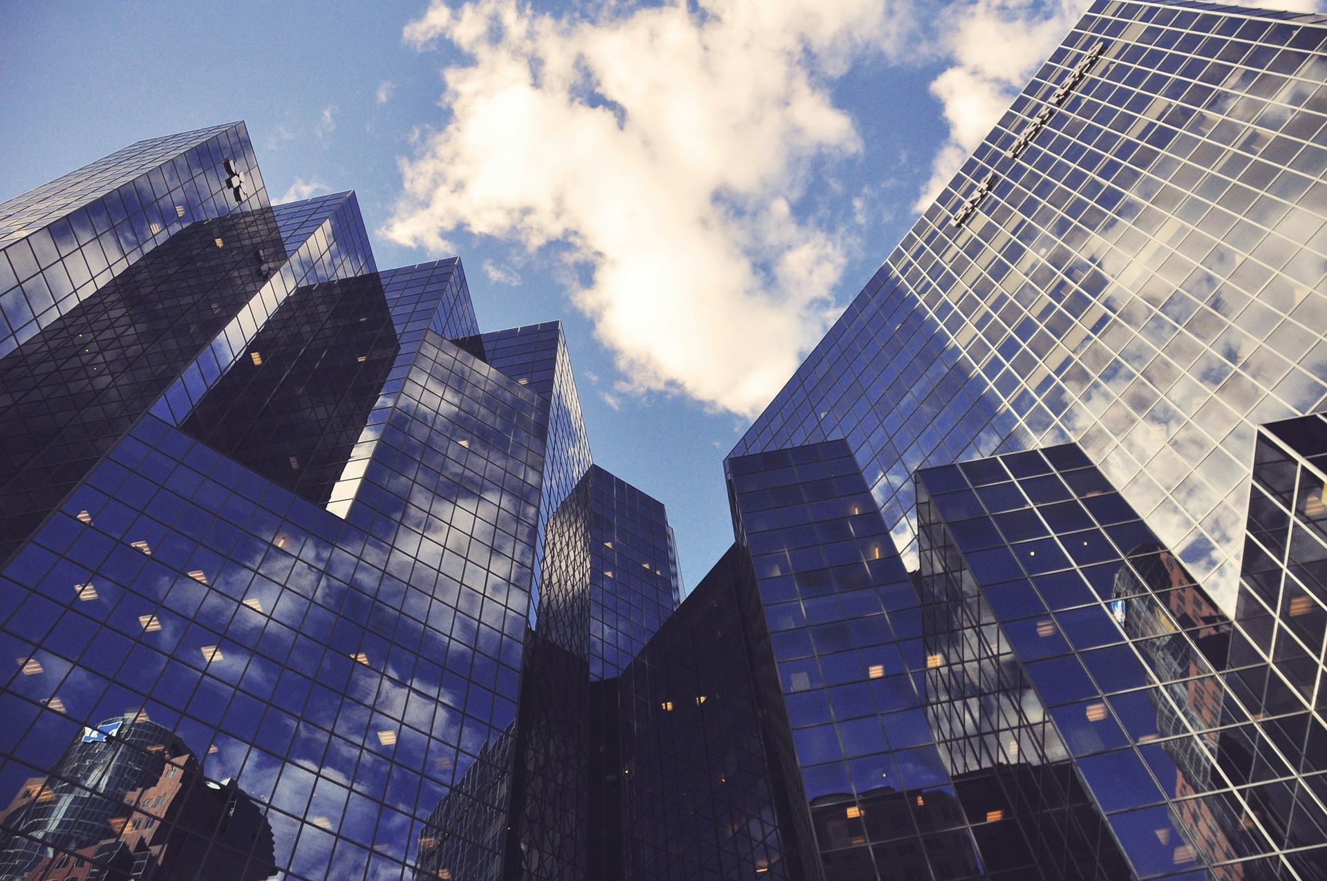 Looking up at a group of tall buildings with a blue sky in the background.
