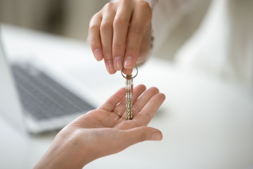 Two Hands Exchanging Keys — Kellie O'Malley Conveyancing In Lake Munmorah, NSW
