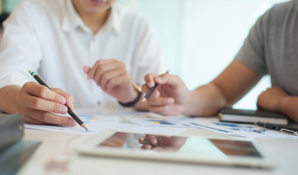 Two People Reviewing Documents, Using Pencils at a Desk — Kellie O'Malley Conveyancing In Lake Munmorah, NSW