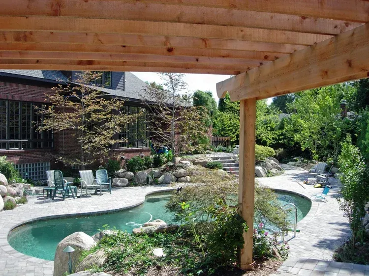 Covered patio overlooking a landscaped courtyard with a small pool and garden seating